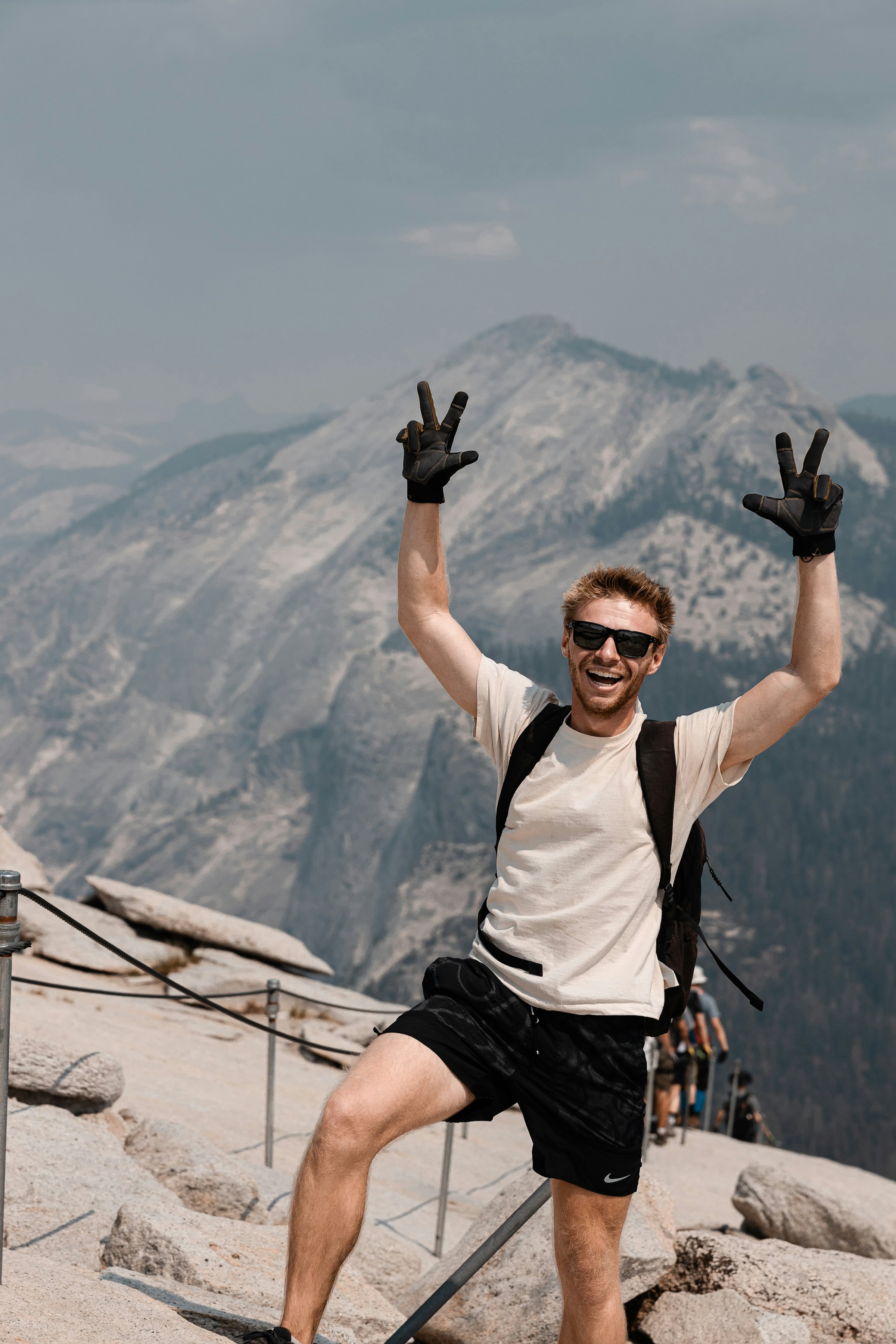 Logan Voss standing on a mountain in Yosemite with his hands in the air